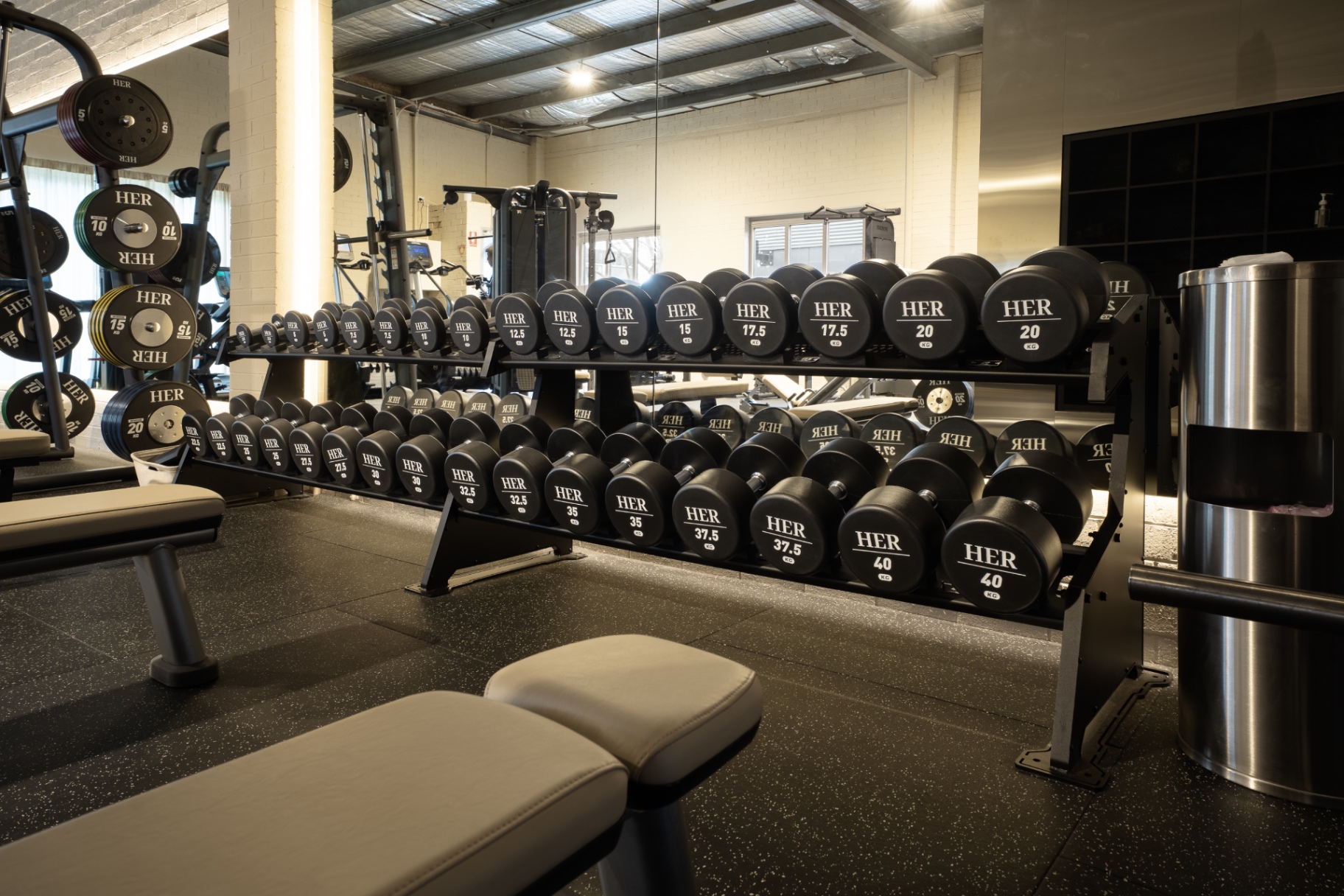 HER-branded dumbbells and benches in the free weights area