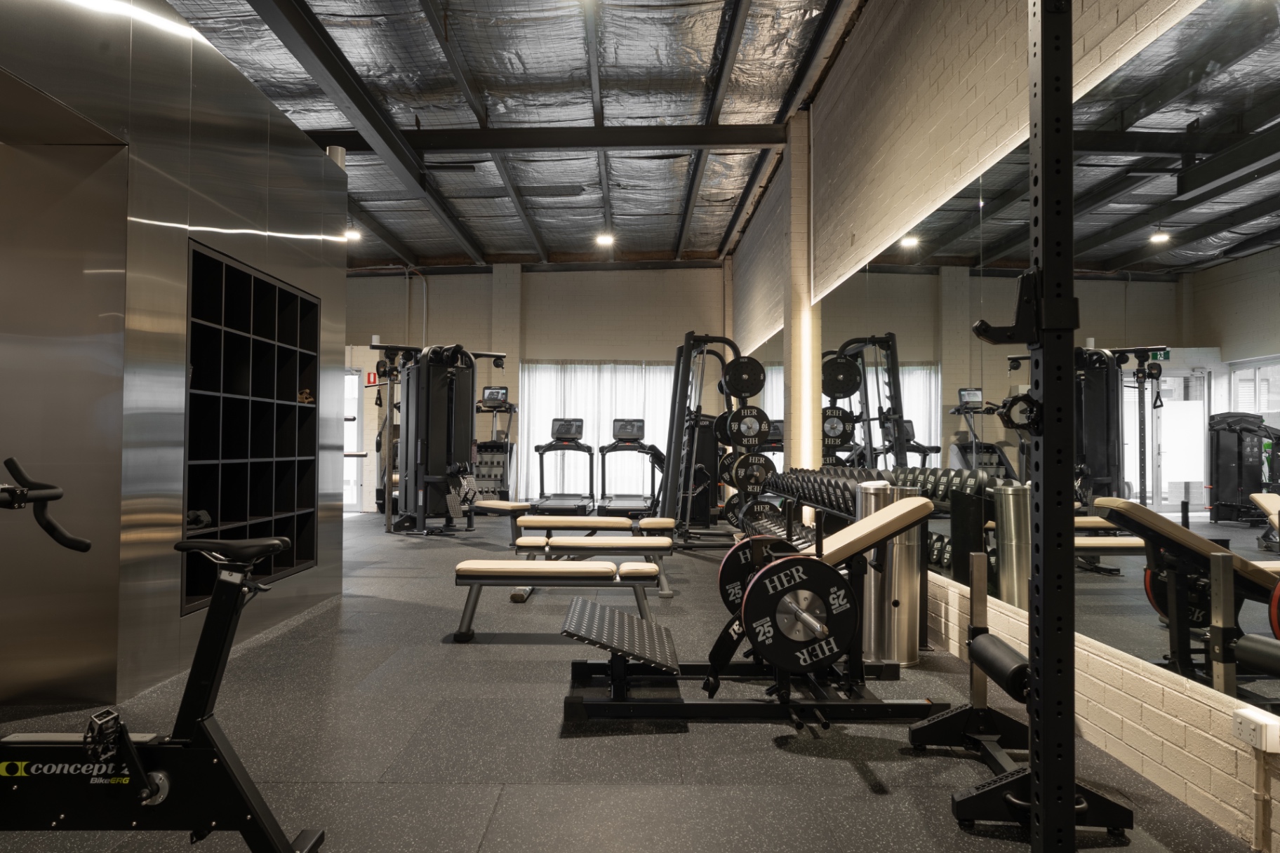 HER Fitness Club open gym with strength machines, benches and free weights