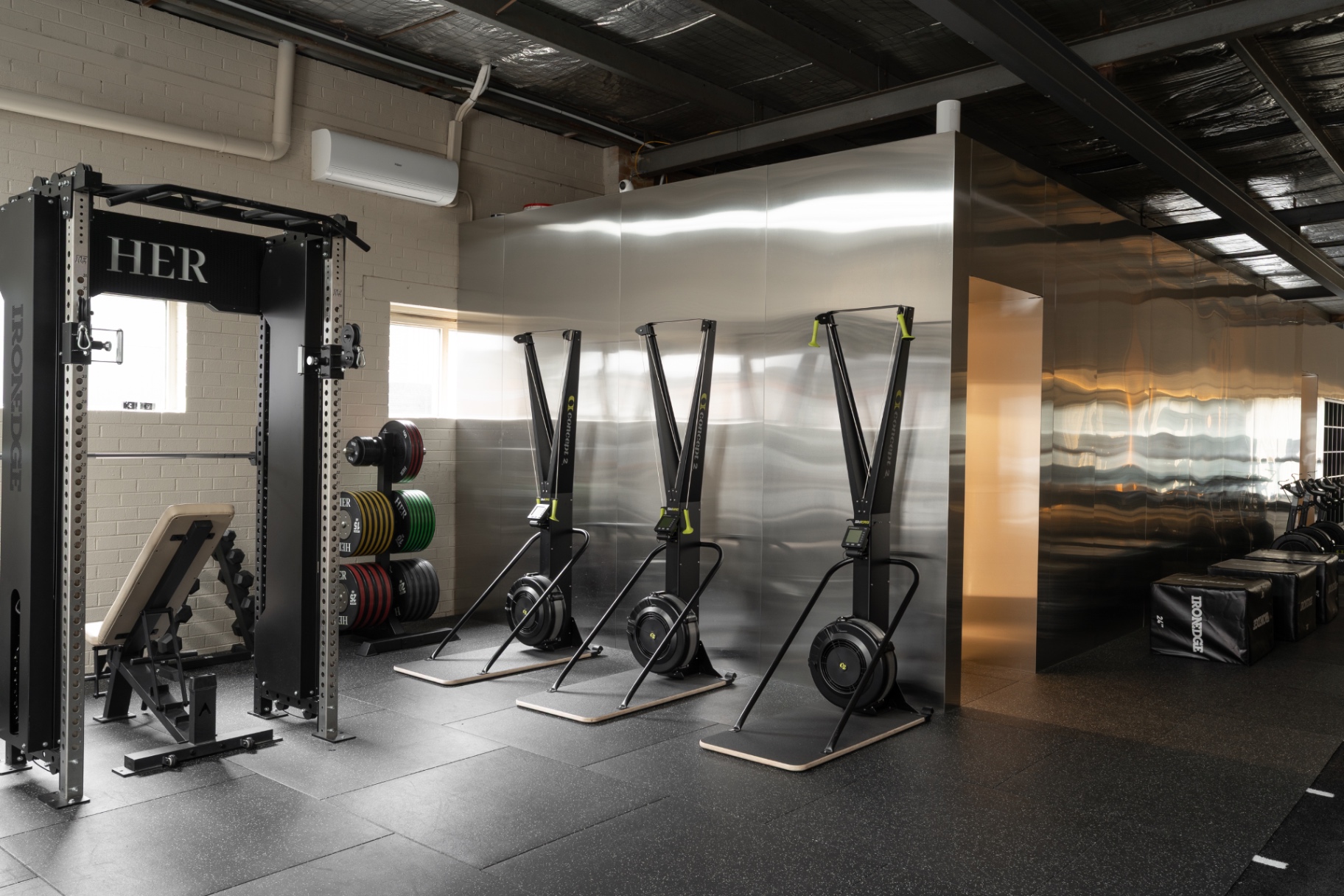 SkiErg machines beside the silver gym walls